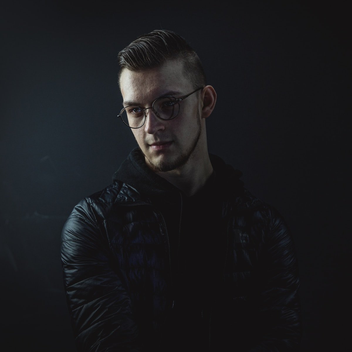man in black leather jacket wearing eyeglasses